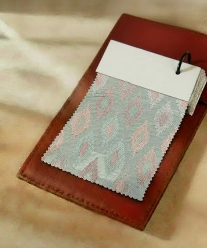 Textured fabric sample on a brown leather surface